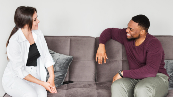 a man and a woman talking on a couch